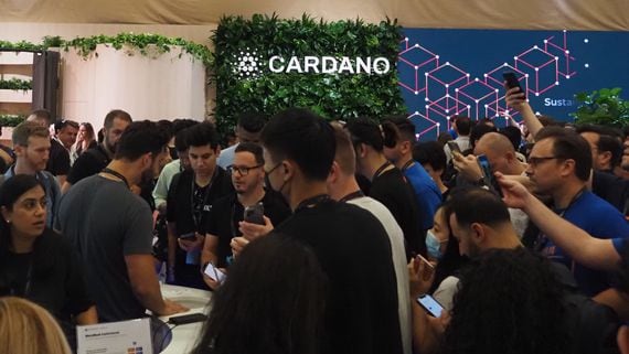 A crowd looks past the Cardano booth at Consensus 2022 in Austin, Texas. (Danny Nelson/CoinDesk)
