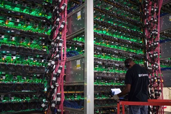 A technician monitors cryptocurrency mining rigs at a Bitfarms facility in Saint-Hyacinthe, Quebec, Canada.