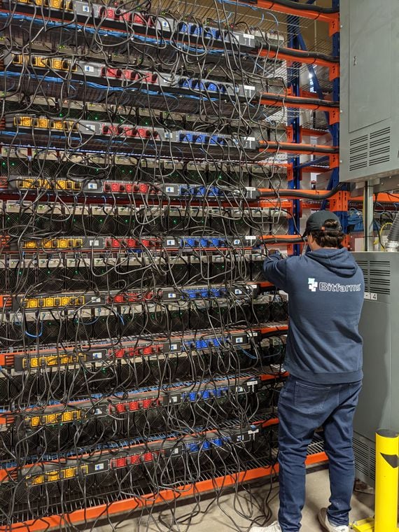 A Bitfarms employee inspecting miners at Cowansville, Quebec, Canada. (Aoyon Ashraf/CoinDesk)