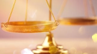 Law scales on table, close-up view (artisteer/iStock/Getty Images Plus)