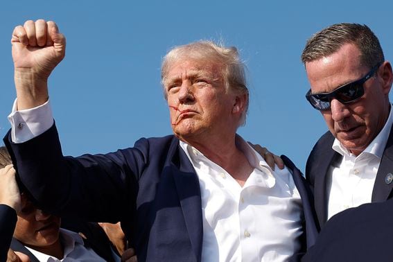 BUTLER, PENNSYLVANIA - JULY 13: Republican presidential candidate former President Donald Trump pumps his fist as he is rushed offstage by U.S. Secret Service agents after being grazed by a bullet during a rally on July 13, 2024 in Butler, Pennsylvania. Butler County district attorney Richard Goldinger said the shooter is dead after injuring former U.S. President Donald Trump, killing one audience member and injuring another in the shooting. (Photo by Anna Moneymaker/Getty Images)