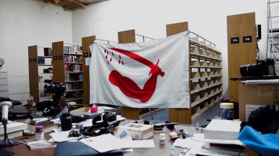 The library and Goliad flag in Defense Distributed's Austin, Texas, office, in a scene from "Death Athletic." (Jessica Solce)