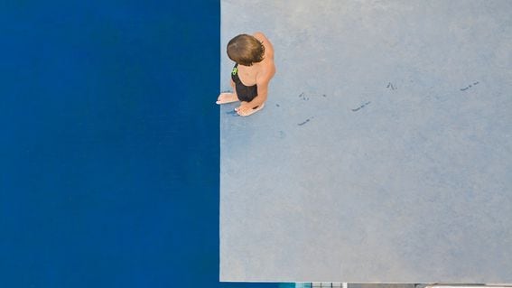 A boy standing on diving board. (Photo and Co/Getty Images)