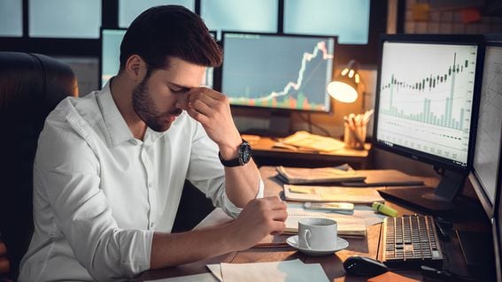 Depressed frustrated trader tired of overwork or stressed by bankruptcy, sad shocked investor desperate about financial crisis or money loss, upset businessman having headache massaging nose bridge (Getty Images)